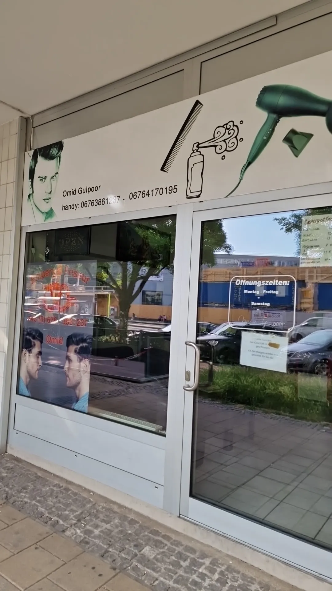 Eingang des Salons mit Öffnungszeiten an der Glastür